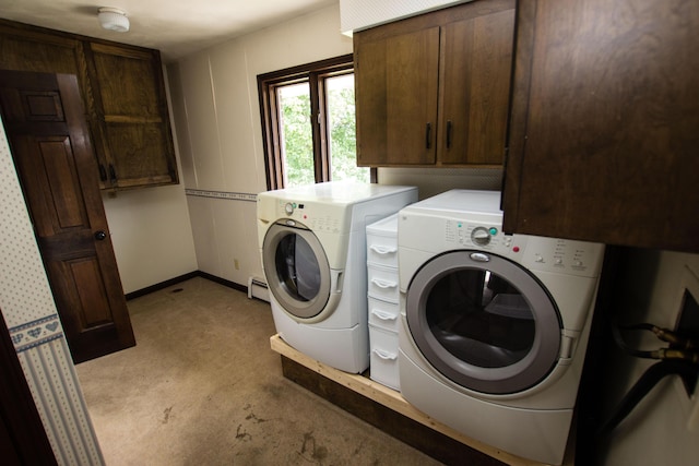 clothes washing area featuring cabinets and washing machine and clothes dryer