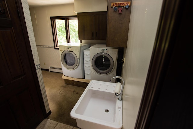 washroom with sink, cabinets, washer and dryer, and a baseboard heating unit