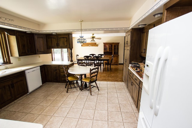 kitchen featuring sink, hanging light fixtures, ceiling fan, dark brown cabinets, and white appliances