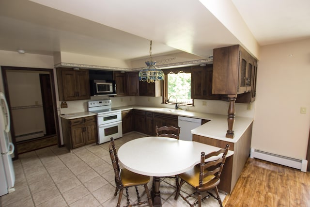 kitchen featuring a baseboard radiator, sink, pendant lighting, and white appliances