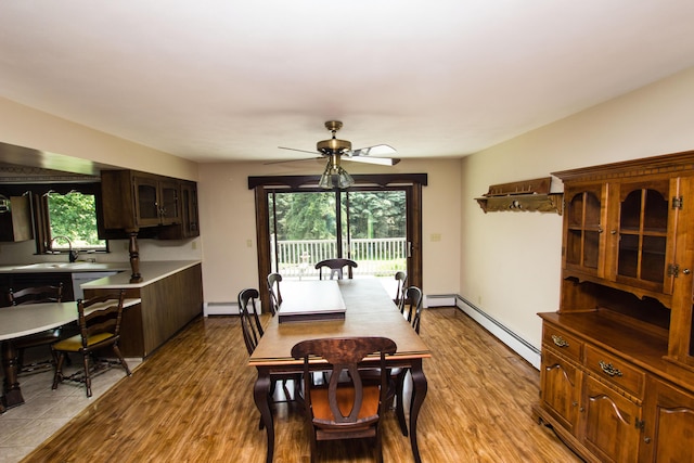 dining area featuring baseboard heating, ceiling fan, sink, and a wealth of natural light