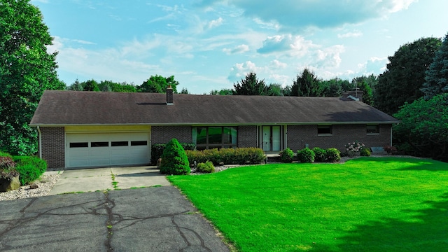 ranch-style house featuring a garage and a front lawn