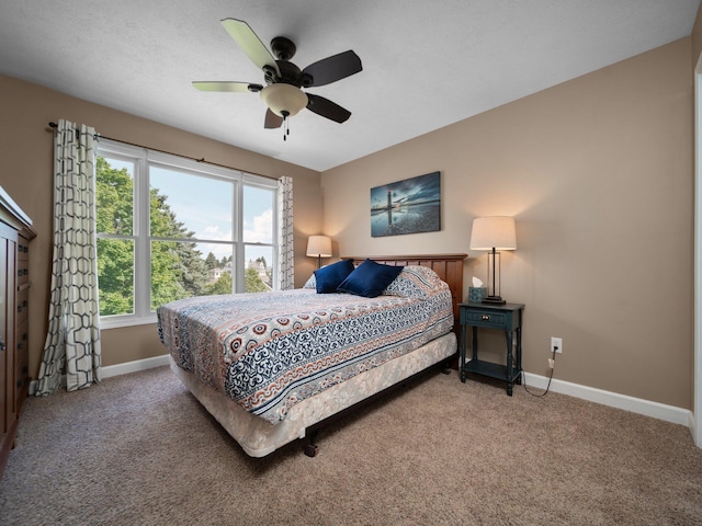 carpeted bedroom with baseboards and ceiling fan