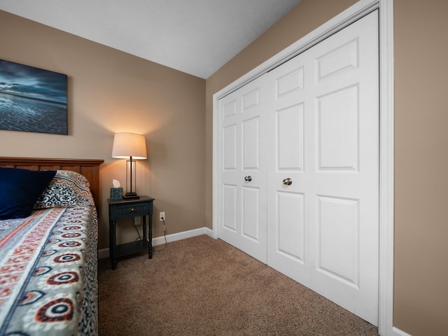 carpeted bedroom with a closet and baseboards