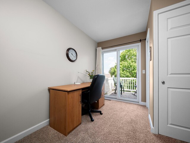 carpeted home office with lofted ceiling