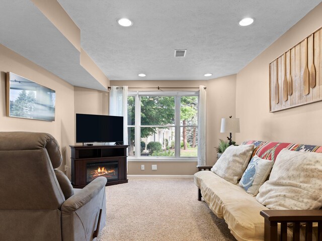 carpeted living room featuring a textured ceiling