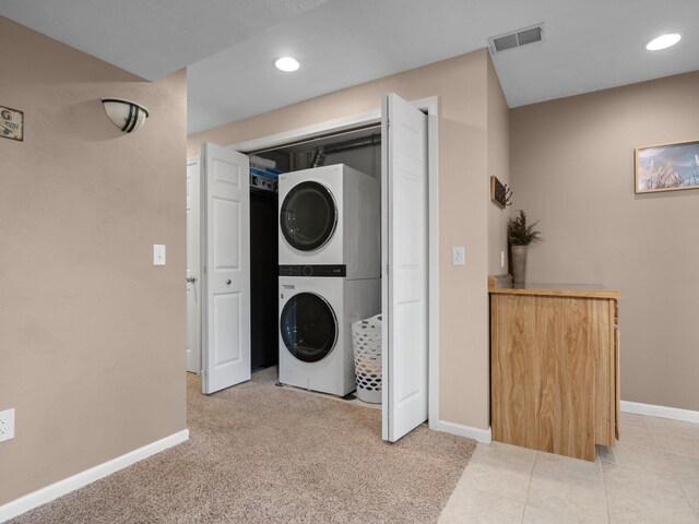 washroom featuring light carpet and stacked washer and clothes dryer