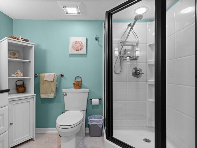 bathroom featuring tile patterned flooring, toilet, and a shower with shower door