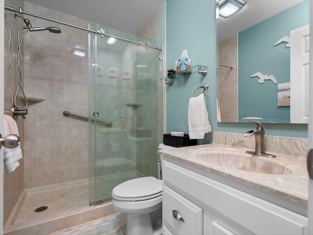 bathroom with vanity, toilet, and a shower with shower door