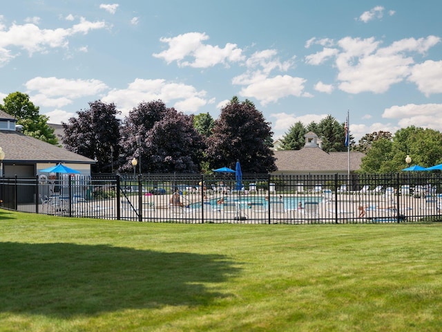 community pool with a yard and fence