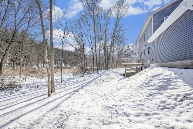 yard covered in snow featuring a deck