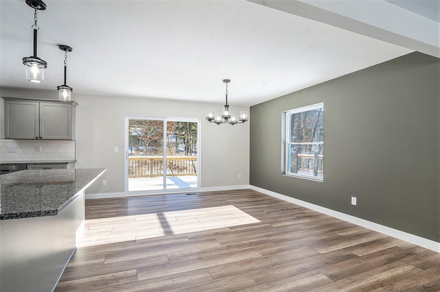 unfurnished dining area featuring light hardwood / wood-style flooring and an inviting chandelier