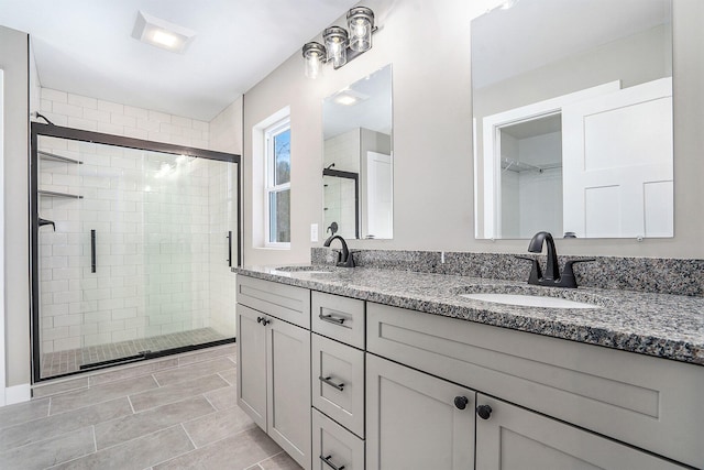 bathroom featuring a shower with door, vanity, and tile patterned flooring