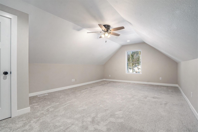 bonus room with a textured ceiling, carpet floors, vaulted ceiling, and ceiling fan