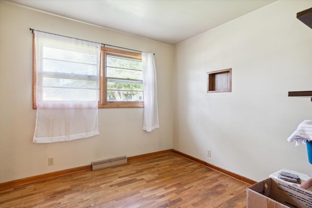 interior space featuring baseboard heating and light wood-type flooring