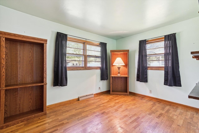 unfurnished room featuring a baseboard radiator and wood-type flooring