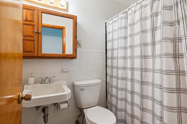 bathroom featuring tile walls, decorative backsplash, sink, and toilet