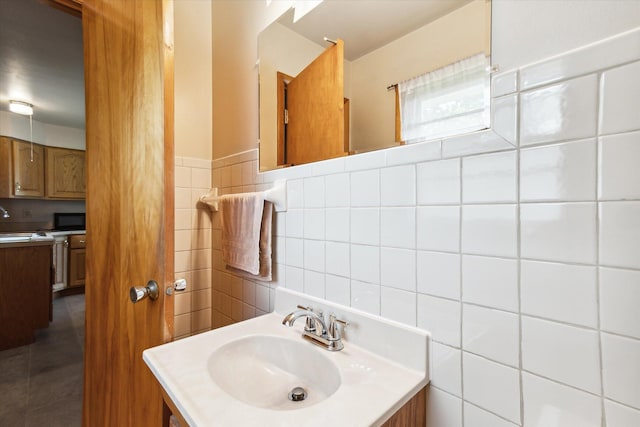 bathroom featuring vanity and tile walls