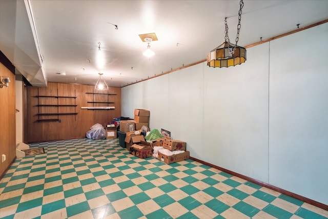 basement featuring wooden walls and light tile patterned floors