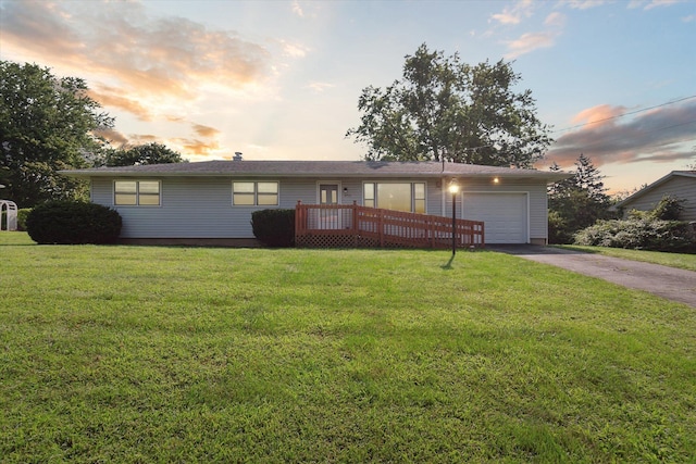 ranch-style home featuring a wooden deck, a garage, and a yard