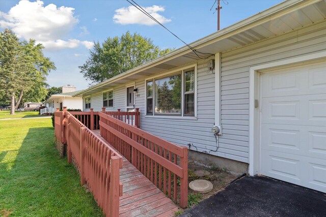 exterior space with a garage and a lawn