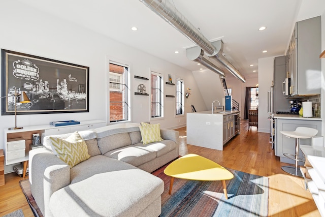 living room with sink and light hardwood / wood-style floors