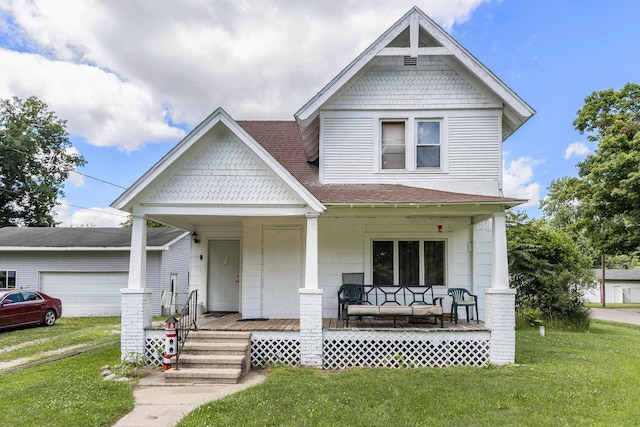 victorian house featuring a garage, covered porch, a front lawn, and roof with shingles