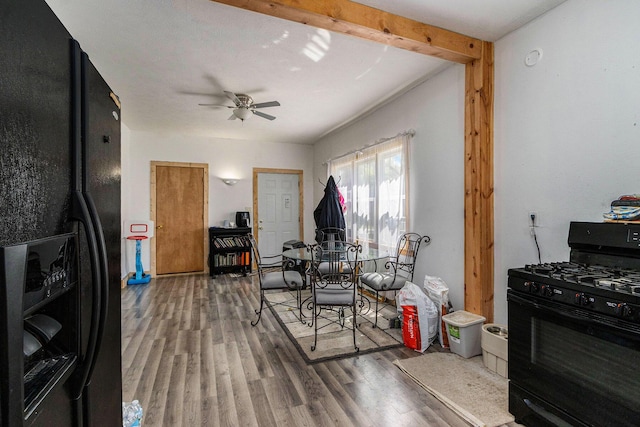 kitchen with ceiling fan, black appliances, wood finished floors, and beam ceiling