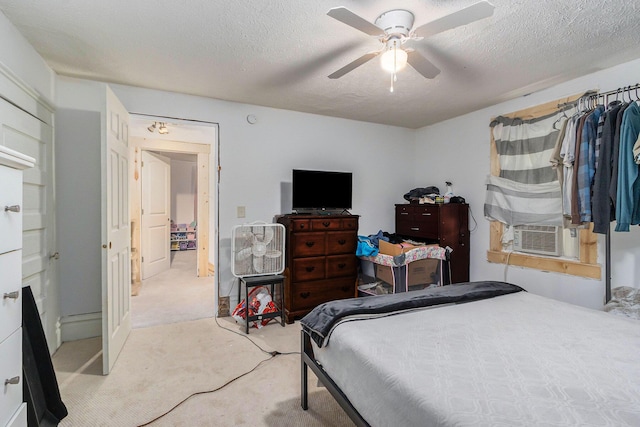 bedroom with cooling unit, carpet flooring, ceiling fan, and a textured ceiling