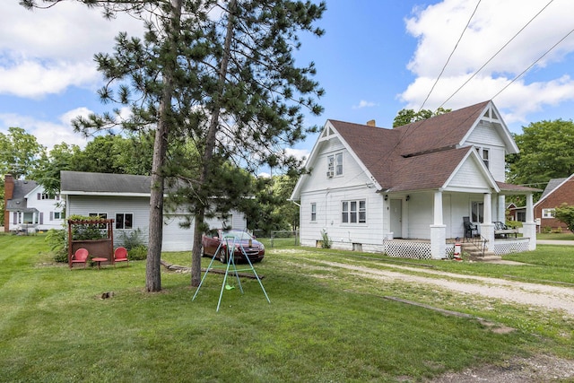 view of home's exterior featuring covered porch, roof with shingles, a yard, and a chimney