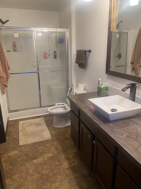 bathroom with vanity, a shower with shower door, and toilet