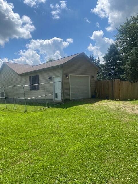 rear view of house featuring a yard and a garage