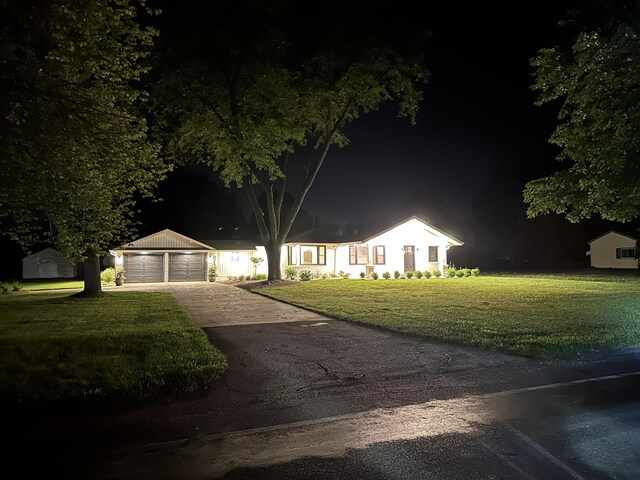 view of front of house featuring an outbuilding, a lawn, a carport, and a garage