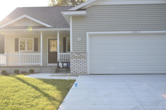 view of front of house featuring a porch, a garage, and a front yard