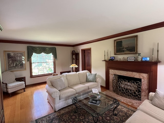 living room with ornamental molding, a high end fireplace, and light hardwood / wood-style floors