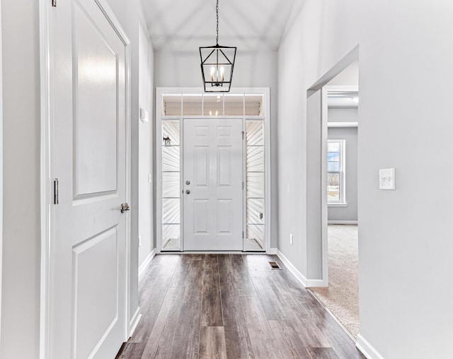 carpeted foyer featuring a chandelier