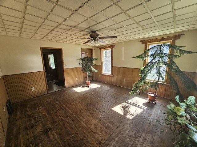 interior space with dark hardwood / wood-style floors, a paneled ceiling, and ceiling fan