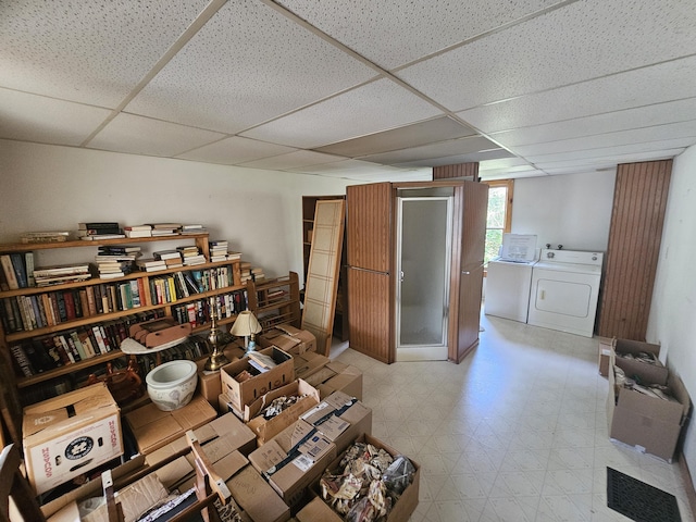 living area with a paneled ceiling and separate washer and dryer