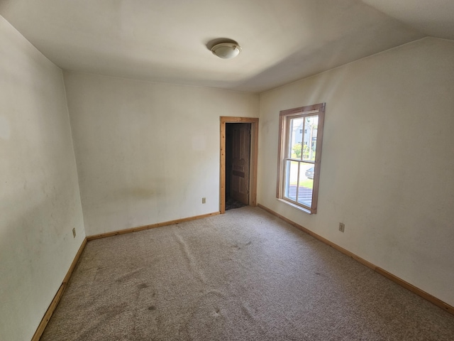 unfurnished room with lofted ceiling and carpet flooring