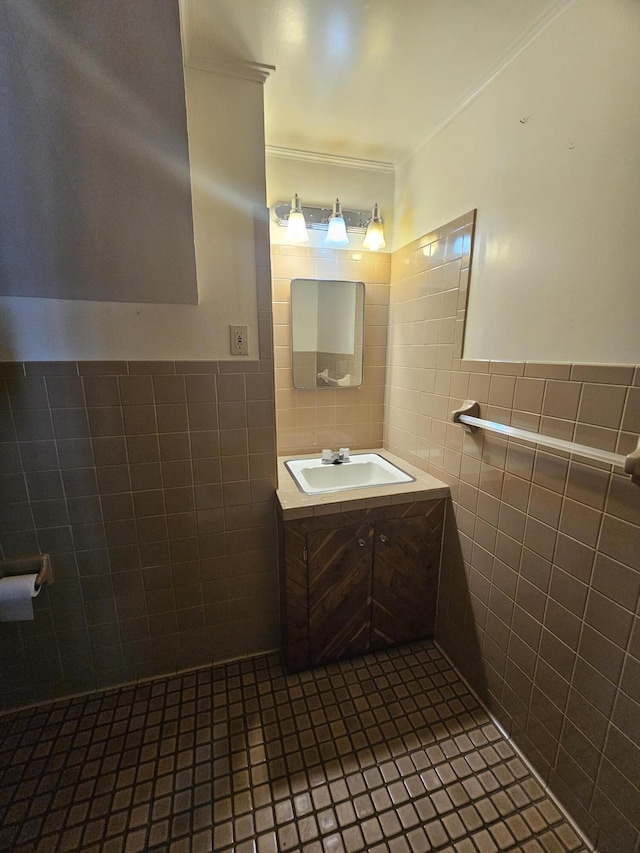 bathroom with tile walls, vanity, ornamental molding, and tile patterned floors