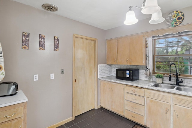 kitchen featuring decorative light fixtures, sink, light brown cabinetry, and decorative backsplash