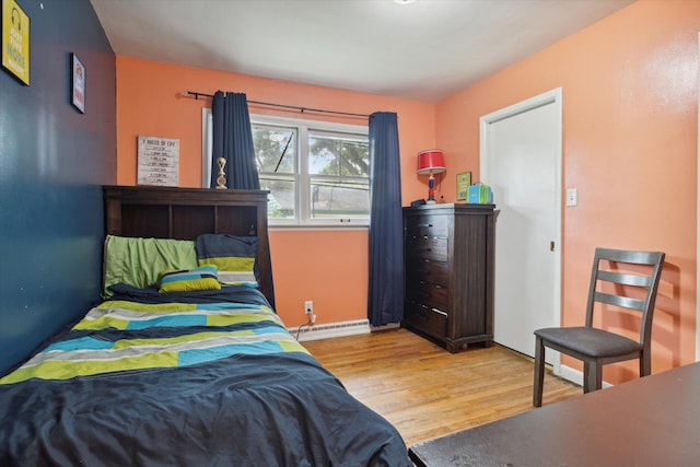 bedroom with baseboard heating and light wood-type flooring