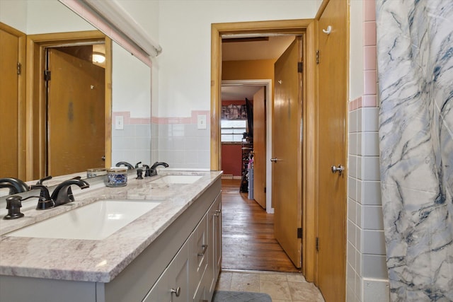 bathroom with vanity and tile walls