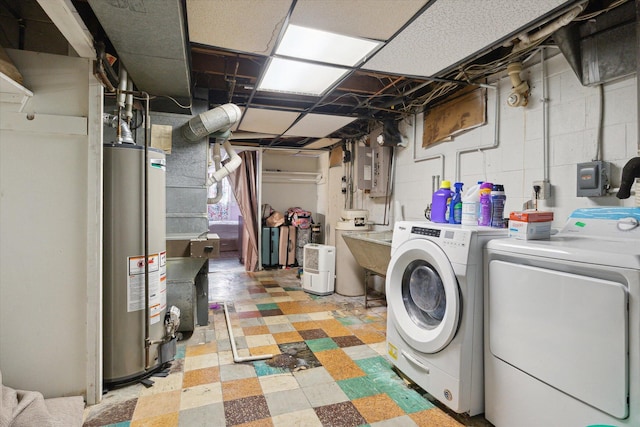 basement with gas water heater, washer and dryer, and sink