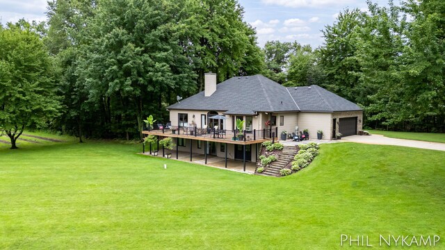 exterior space featuring a garage, a deck, and a lawn