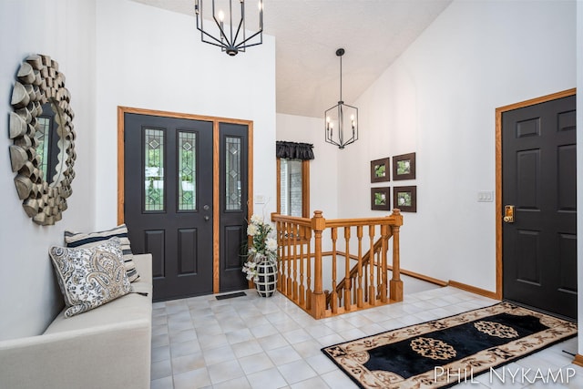 tiled foyer with a notable chandelier and high vaulted ceiling