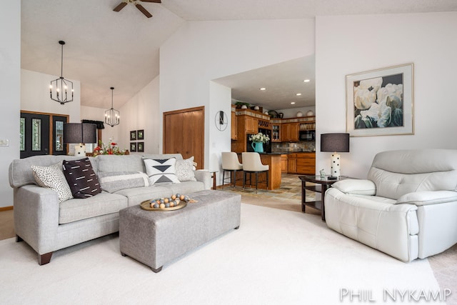 living room featuring ceiling fan with notable chandelier, light carpet, and high vaulted ceiling