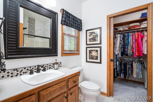 bathroom with toilet, vanity, tile patterned floors, and walk in shower