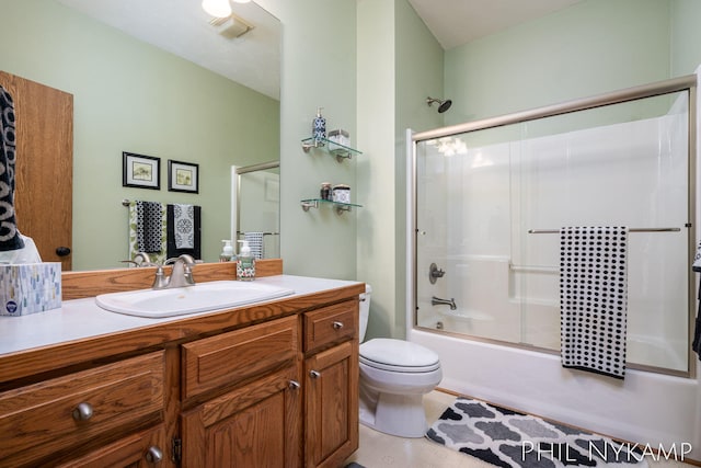 full bathroom featuring vanity, toilet, and combined bath / shower with glass door