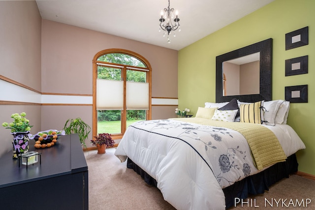 carpeted bedroom featuring an inviting chandelier